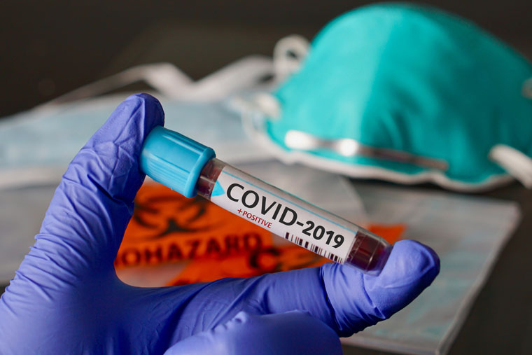 Gloved health care professional holding a COVID-2019 sample tube