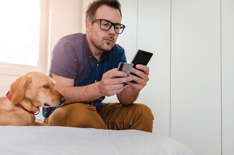 Man with his dog shopping on a smartphone