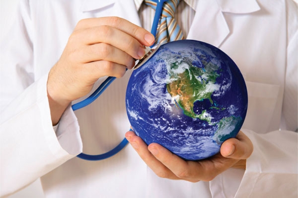 Medical professional holding a small earth globe